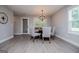 Well-lit dining room featuring a round table with chairs, a modern chandelier, and a large window at 328 Brookstone Dr, Carrollton, GA 30116