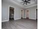 Open bedroom with tray ceilings, ceiling fan, and a view of the bathroom and walk-in closets at 328 Brookstone Dr, Carrollton, GA 30116