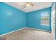This bedroom is freshly painted with blue walls, a ceiling fan, and neutral carpeting at 4753 Klondike Cv, Lithonia, GA 30038