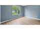 Serene bedroom featuring wood-look floors and a window with a view of the greenery outside at 4753 Klondike Cv, Lithonia, GA 30038