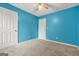 The bedroom offers neutral carpeting, an overhead fan, and freshly painted blue walls at 4753 Klondike Cv, Lithonia, GA 30038