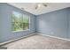 This well-lit bedroom features carpeted floors and a large window to enjoy the view at 4753 Klondike Cv, Lithonia, GA 30038