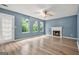 Open living room featuring a fireplace, ceiling fan, and large windows for natural light at 4753 Klondike Cv, Lithonia, GA 30038