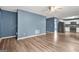Open concept living room with wood-look floors that connects to kitchen featuring stainless appliances and white cabinets at 4753 Klondike Cv, Lithonia, GA 30038