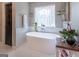 Elegant bathroom featuring a freestanding tub, decorative window, and modern fixtures at 130 Bexar Ct, Johns Creek, GA 30022