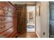 Hardwood floors with dresser and barn door leading to an open area with shelves and décor at 130 Bexar Ct, Johns Creek, GA 30022