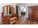 Dressing area with a dressing table and mirrors, wood floors, and an open view to the main bedroom at 130 Bexar Ct, Johns Creek, GA 30022