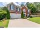 Charming two-story home featuring a brick facade, gray siding, an attached garage, and a well-manicured front lawn at 130 Bexar Ct, Johns Creek, GA 30022