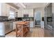 A well-lit kitchen with white cabinets, stainless steel appliances, and a wooden island at 130 Bexar Ct, Johns Creek, GA 30022