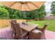 Outdoor dining area offers a relaxed setting for meals under the umbrella, surrounded by the serene green backyard at 130 Bexar Ct, Johns Creek, GA 30022