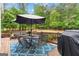 Outdoor deck with dining table, umbrella, and view of wooded backyard at 495 Stonehaven Dr, Fayetteville, GA 30215