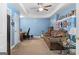 Finished basement with blue walls, a brown leather sofa, a work station, and overhead fan at 495 Stonehaven Dr, Fayetteville, GA 30215