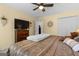 Bedroom with a large TV, dresser, and bed with decorative pillows at 495 Stonehaven Dr, Fayetteville, GA 30215