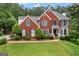 Traditional brick home with manicured lawn, dark shutters, and detailed architectural features at 495 Stonehaven Dr, Fayetteville, GA 30215