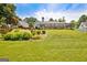 Wide angle of expansive backyard with lush green lawn, mature trees, and a screened-in porch at 316 Kensington Dr, Peachtree City, GA 30269