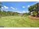 Serene backyard view overlooking a peaceful lake, mature trees and green lawn at 316 Kensington Dr, Peachtree City, GA 30269