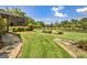 Backyard area with stone pathway with views of a tranquil pond, lush greenery, and mature trees at 316 Kensington Dr, Peachtree City, GA 30269