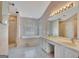 Bright bathroom featuring a jacuzzi tub beneath shuttered windows, with double sinks and a glass shower at 316 Kensington Dr, Peachtree City, GA 30269