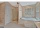 Bathroom featuring a white jacuzzi tub beneath shuttered windows with a glass shower and a security camera at 316 Kensington Dr, Peachtree City, GA 30269