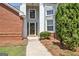 Close-up of the front door with sidelights and decorative glass, flanked by brick and greenery at 316 Kensington Dr, Peachtree City, GA 30269