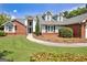 Attractive front exterior featuring brick accents, dormer windows, and a green lawn at 316 Kensington Dr, Peachtree City, GA 30269