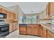 Functional kitchen with granite countertops, wooden cabinets, and tile flooring at 316 Kensington Dr, Peachtree City, GA 30269