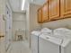 Well-equipped laundry room with a washer, dryer, utility sink, tiled floors, and oak cabinetry at 316 Kensington Dr, Peachtree City, GA 30269