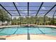 Inviting screened-in pool with a rock feature and a view of the surrounding trees at 316 Kensington Dr, Peachtree City, GA 30269