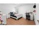 Well-lit bedroom featuring white wood floors, a large window, and modern furniture at 9477 Forest Knoll Dr, Jonesboro, GA 30238
