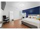 Bright bedroom features hardwood floors, blue accent wall, vanity, and natural light at 9477 Forest Knoll Dr, Jonesboro, GA 30238
