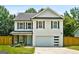 Charming two-story home with a well-manicured lawn, light blue front door, and a spacious two-car garage at 9477 Forest Knoll Dr, Jonesboro, GA 30238