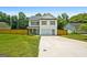 Inviting two-story home with a manicured lawn and attached garage, complemented by a charming blue front door at 9477 Forest Knoll Dr, Jonesboro, GA 30238