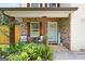 Cozy front porch with brick columns, seating area, and a light blue front door, creating a welcoming entrance at 9477 Forest Knoll Dr, Jonesboro, GA 30238