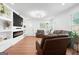Modern living room features a fireplace, custom shelving, and comfortable seating with natural light at 9477 Forest Knoll Dr, Jonesboro, GA 30238