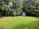 Large backyard with lush greenery and a shed tucked away in the background at 1041 Sandy Ridge Rd, Mcdonough, GA 30252