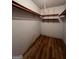 Walk-in closet featuring hardwood floors, overhead lighting, and multiple rows of shelves at 1041 Sandy Ridge Rd, Mcdonough, GA 30252