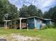 Exterior view of a home with a well-maintained yard, deck, and ramp in a natural setting at 1041 Sandy Ridge Rd, Mcdonough, GA 30252