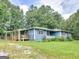 Single-story home featuring a covered deck, front porch, and lush green lawn at 1041 Sandy Ridge Rd, Mcdonough, GA 30252