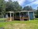 Exterior view of a home with a deck, ramp, and well-maintained yard at 1041 Sandy Ridge Rd, Mcdonough, GA 30252