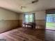 Cozy living room with ample natural light, hardwood flooring, and wood paneling at 1041 Sandy Ridge Rd, Mcdonough, GA 30252