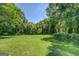 Expansive green backyard surrounded by lush trees, offering a private outdoor space at 403 Chester Piper Rd, Covington, GA 30014