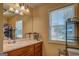 Well-lit bathroom with a large mirror, wooden vanity, and a view of the outdoors through a window at 403 Chester Piper Rd, Covington, GA 30014