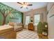 A charming Bedroom features a tree mural, a cozy crib, and playful accents to create a soothing and inviting space at 403 Chester Piper Rd, Covington, GA 30014