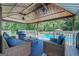 Covered patio with comfortable seating area and view of the sparkling pool at 403 Chester Piper Rd, Covington, GA 30014