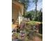 Spacious backyard with mature trees, deck, grass and work equipment, awaiting personalized landscaping at 8778 Homewood Ct, Riverdale, GA 30274