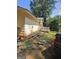 Spacious backyard with mature trees, deck, grass and work equipment, awaiting personalized landscaping at 8778 Homewood Ct, Riverdale, GA 30274