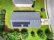 Backyard aerial view featuring well-kept green lawn and trees with solar panels on the roof at 9132 Overlook Dr, Jonesboro, GA 30238