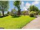 View of a two-story house with a large front lawn and boarded up windows and doors at 145 Windy Ridge Ct, Fayetteville, GA 30214