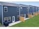 A neat backyard shows the exterior of the townhomes and green lawn at 11555 Kimberly Way, Hampton, GA 30228