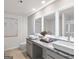 Modern bathroom featuring double sinks with granite countertops and illuminated mirrors at 11555 Kimberly Way, Hampton, GA 30228